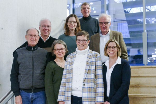 Acht Mitglieder des WTZ Patientenbeirats stehen auf einer Treppe.