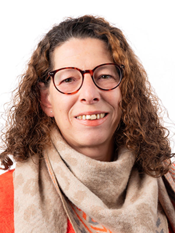 UKM | Portraitaufnahme einer Mitarbeiterin aus dem Sekretariat der Neurochirurgie | Sie hat lange Haare, trägt eine Brille und lächelt