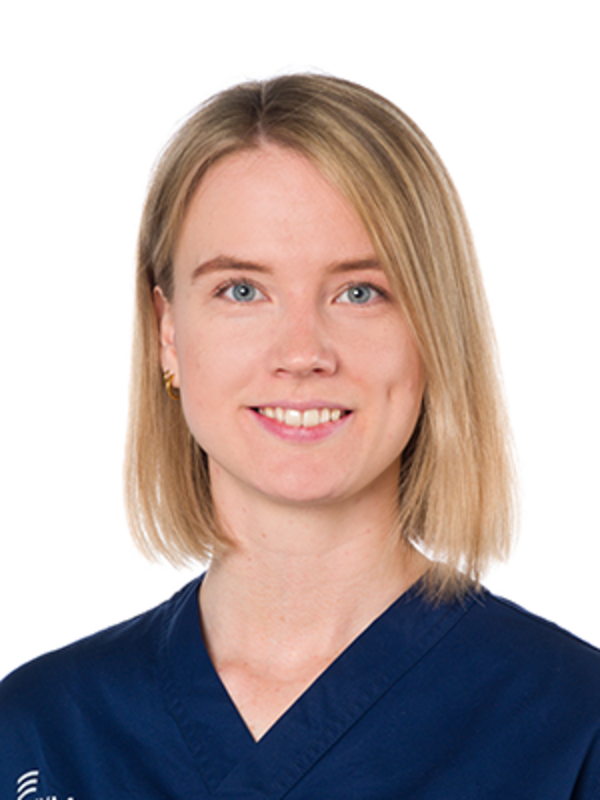 UKM | Mitarbeiterin der Unfallchirurgie. Sie trägt einen dunkelblauen Kasack und lächelt.