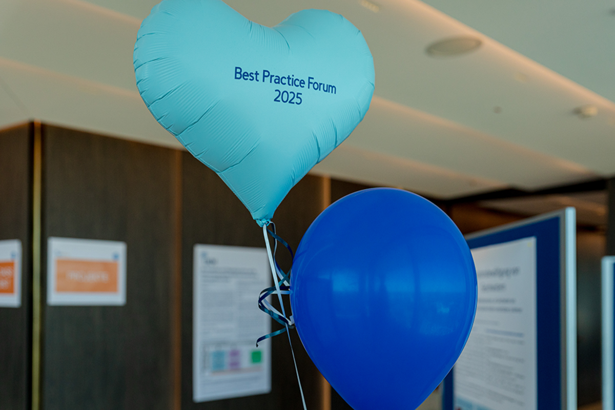 UKM | Ein herzförmiger Luftballon in Türkis mit Aufschrift Best Practice Forum 2025 und ein blauer Luftballon