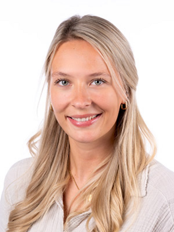 UKM Sozialdienst | Carolin Nestola | Sie hat blonde Haare und lächelt in die Kamera.