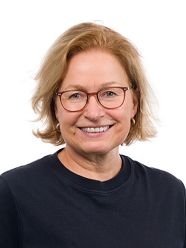 UKM Pädiatrische Hämatologie und Onkologie | Birgit Fröhlich | Sie trägt eine Brille und ein schwarzes Oberteil und lacht in die Kamera.