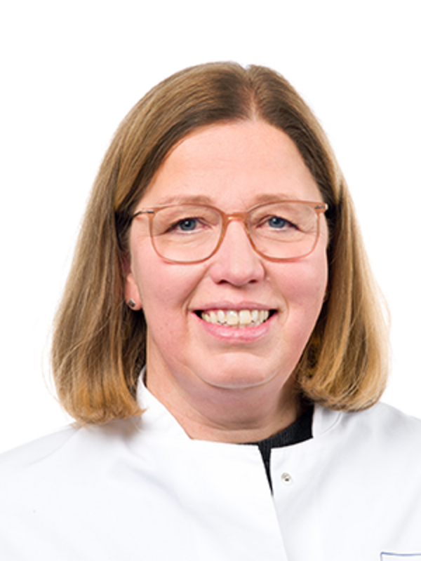 UKM | Labormitarbeiterin der Klinik für Parodontologie. Die Biologin trägt einen weißen Kittel, eine Brille und lächelt.