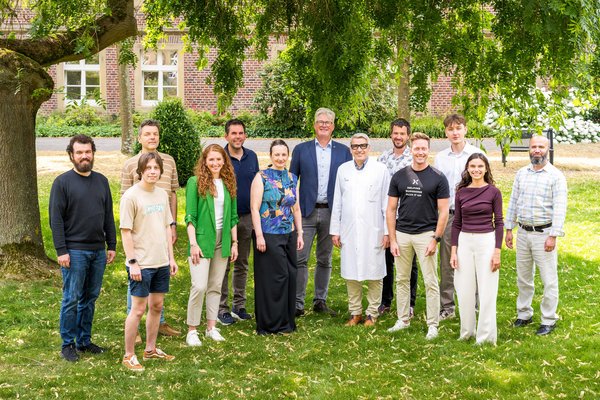 UKM | 13 Mitglieder des deutsch-niederländischen Forschungskonsortium auf einem Rasen unter einem Baum