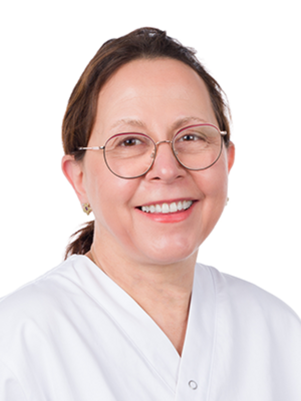 UKM | Portrait einer Dentalhygienikerin der Klinik für Parodontologie. Sie trägt eine Brille, einen weißen Kasack und lächelt.