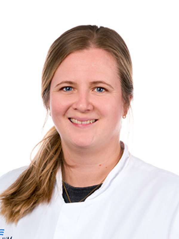 UKM Nuklearmedizin | Anna-Maria Untiet | Sie trägt einen Zopf und einen weißen Kittel und lächelt in die Kamera.