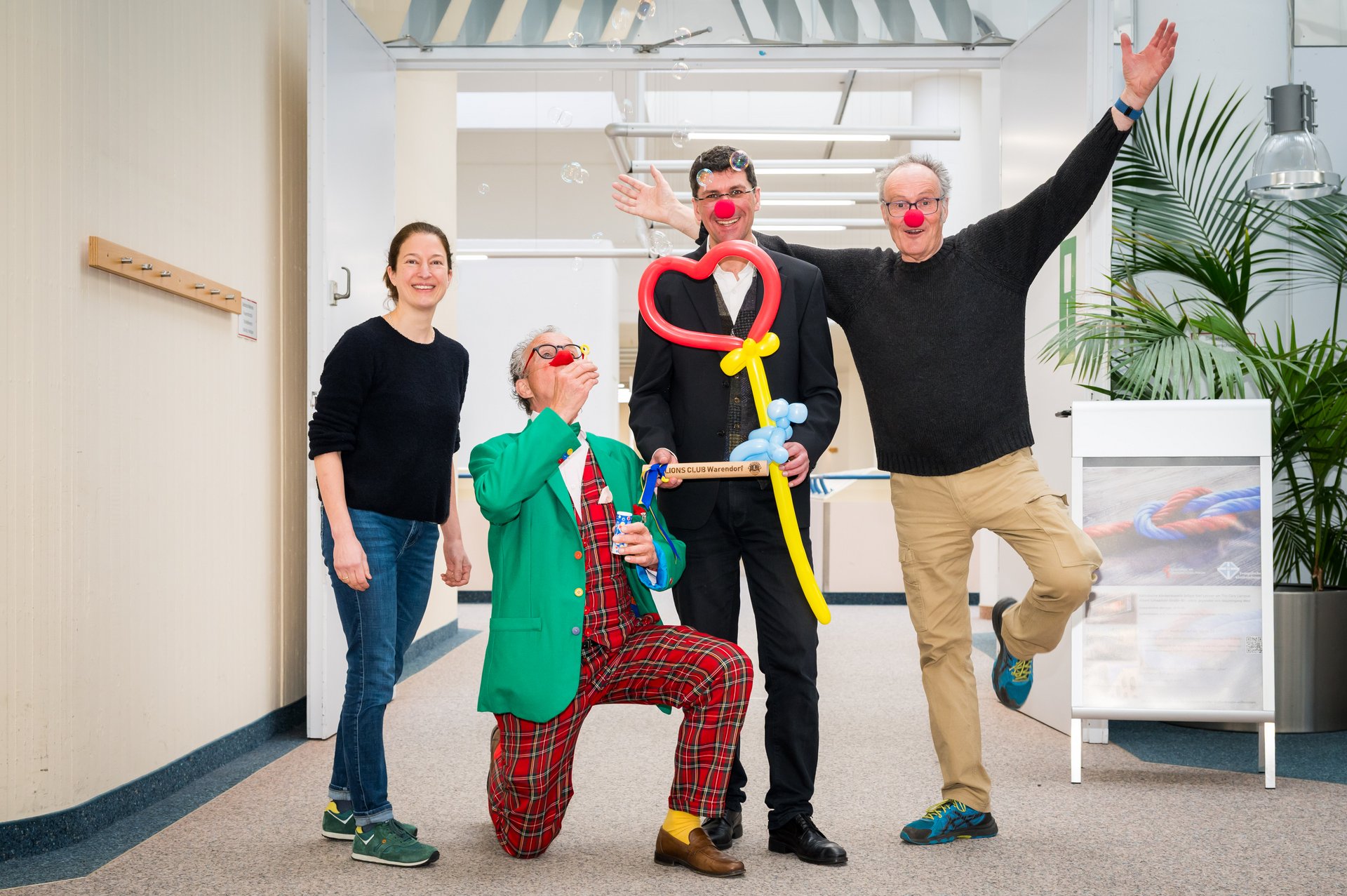 UKM Spenden und Helfen | Gruppenbild mit einer Frau und drei Männern. Die Männer haben Clowns-Nasen auf und posen für die Kamera. Alle lachen.