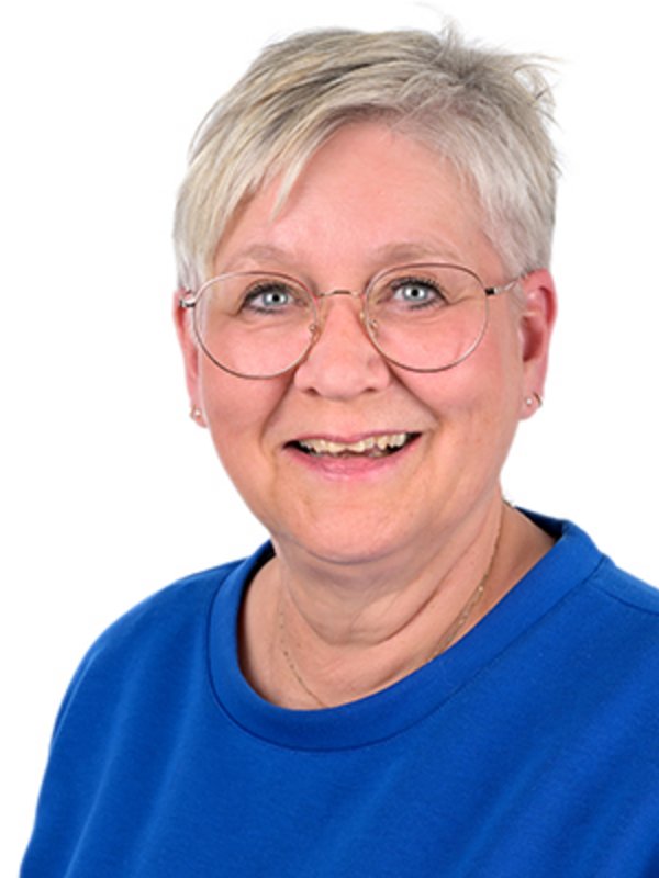 UKM Kompetenzzentrum Chronischer Pruritus | Birgit Tinkloh | Sie trägt ein blaues Oberteil und eine Brille und lächelt in die Kamera.