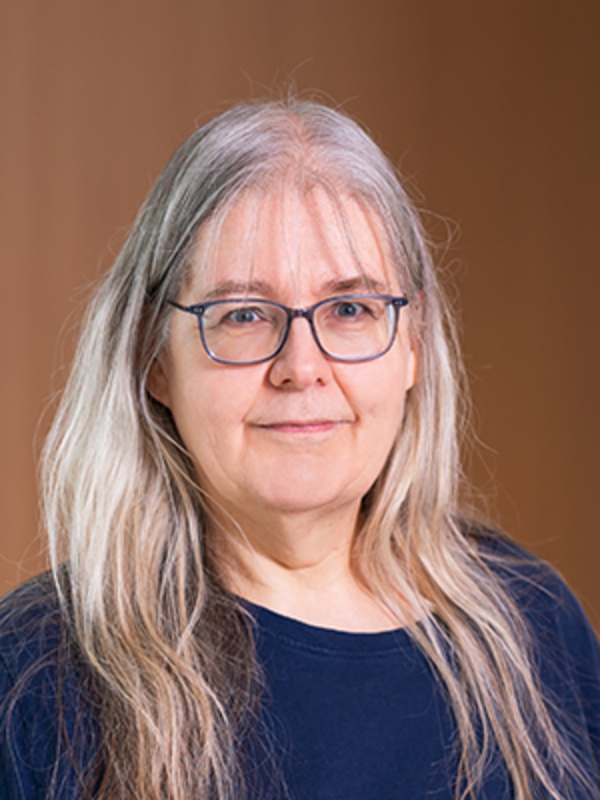 UKM | Portraitaufnahme einer Tumorboardkoordinatorin. Die Frau trägt eine Brille und lächelt.