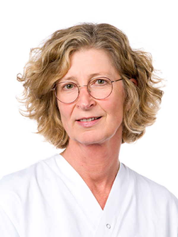 UKM | Portraitaufnahme von Marion Weßels von der Palliativstation. Sie trägt einen weißen Kasack und lächelt.
