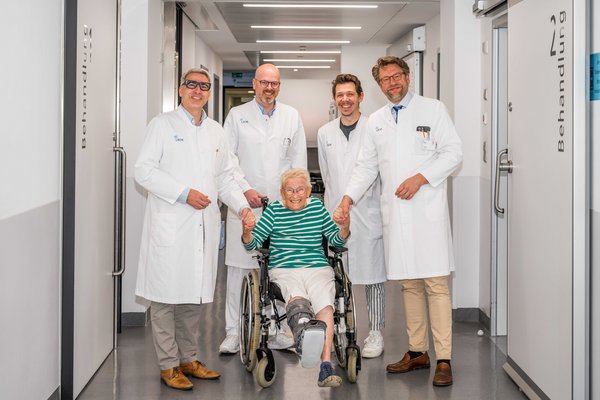 UKM | Presse | Vier Ärzte im weißen Kittel und Patientin im Rollstuhl