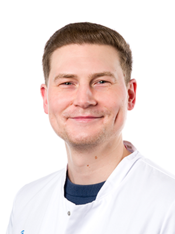 UKM | Portrait eines Zahnarztes der Klinik für Parodontologie. Er trägt einen weißen Kittel und lächelt.