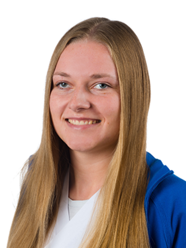 UKM | Portraitfoto einer Medizinischen Fachangestellten aus der Angiologie. Sie trägt einen weißen Kasack und eine blaue Jacke und lächelt.