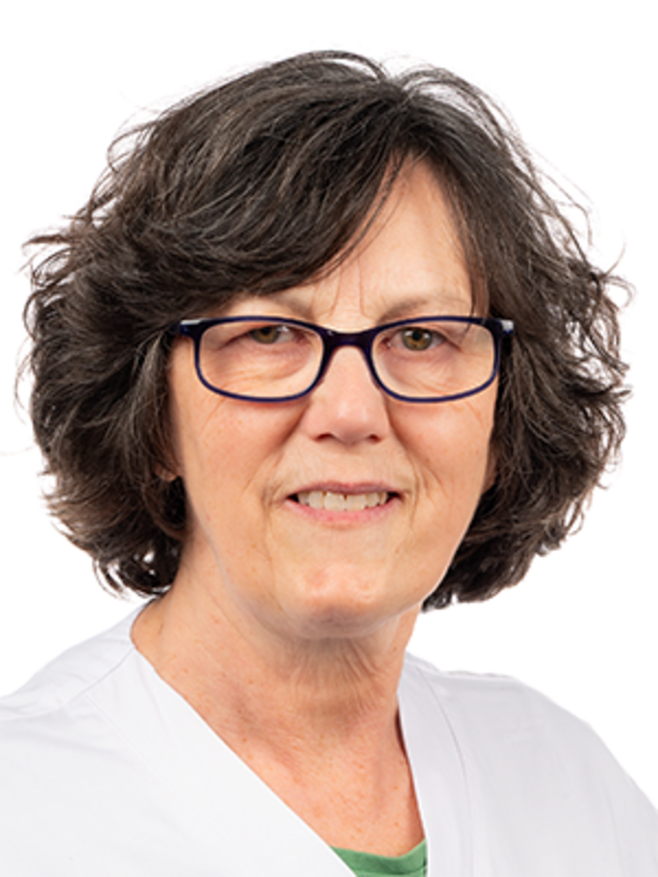 UKM | Zahnmedizinische Prophylaxeassistentin in der Parodontologie. Sie trägt einen weißen Kasack und lächelt.