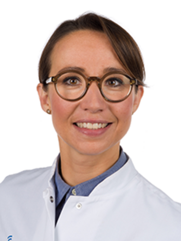 UKM | Ärztin aus der Neurologie, sie trägt einen weißen Kittel und lächelt