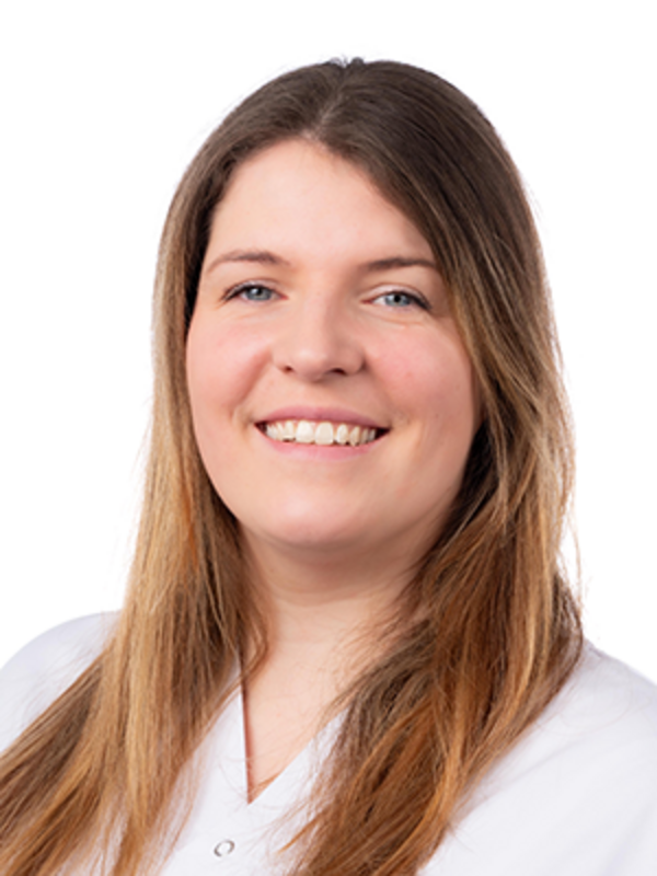 UKM | Zahnmedizinische Fachangestellte aus der Klinik für Parodontologie. Sie trägt einen weißen Kasack und lacht.