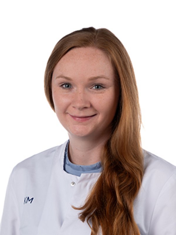 UKM Strahlentherapie - Radioonkologie | Jolisa Maria Brüggenjürgen | Sie trägt einen weißen Kittel und lächelt in die Kamera.