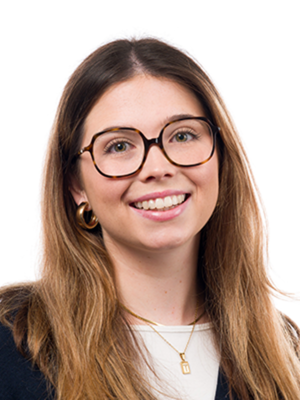 UKM | Portrait einer Zahnmedizinischen Fachangestellten der Poliklinik für Parodontologie | Sie trägt lange Haare, eine große Brille und lächelt.