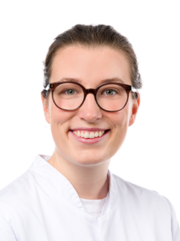 UKM | Zahnärztin der Klinik für Parodontologie. Sie trägt einen weißen Kittel und lächelt.