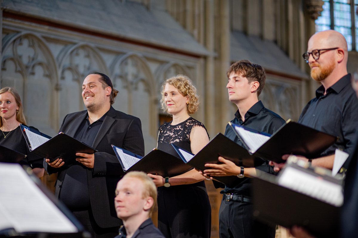 WTZ-Benefizkonzert | Mehrere Chormitglieder halten Notenmappe in den Händen. Sie sind schwarz gekleidet. Foto: UKM/Kochinke