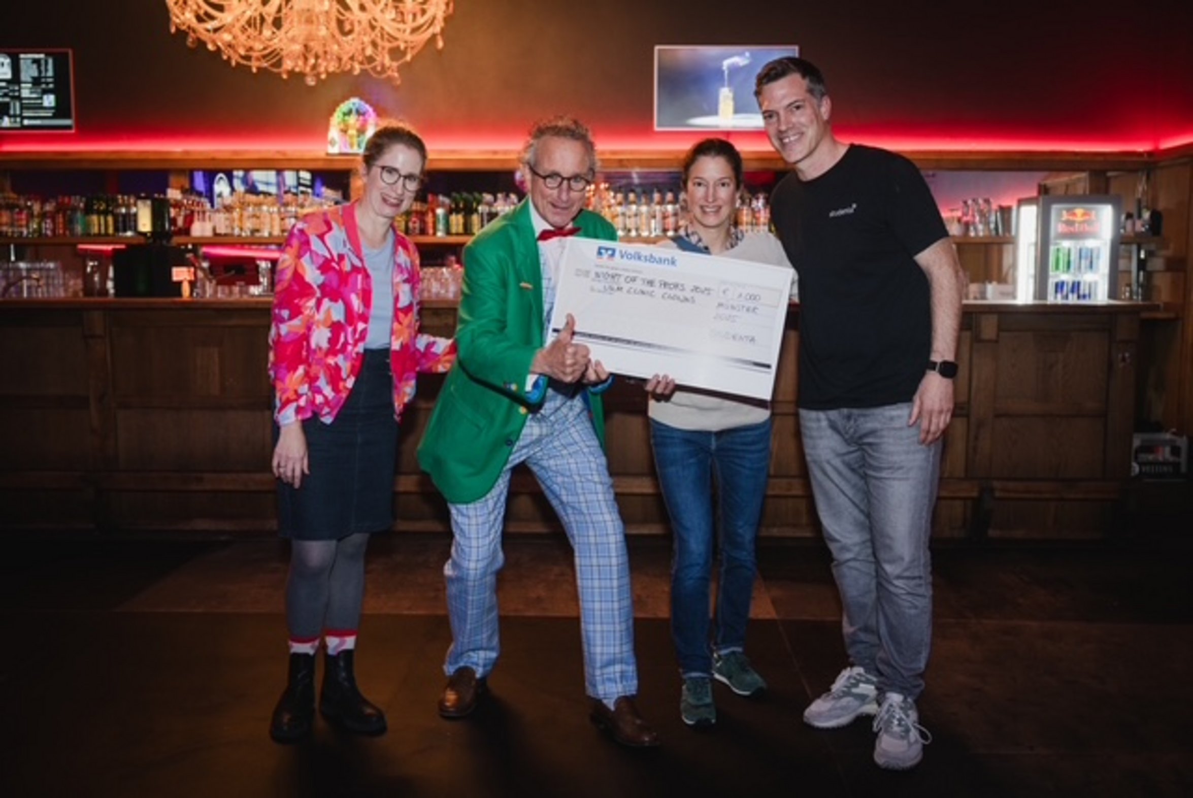 UKM Kultur | Spendenmitteilung | Gruppenfoto zwei Frauen und zwei Männer halten einen Spendencheck in der Hand. 