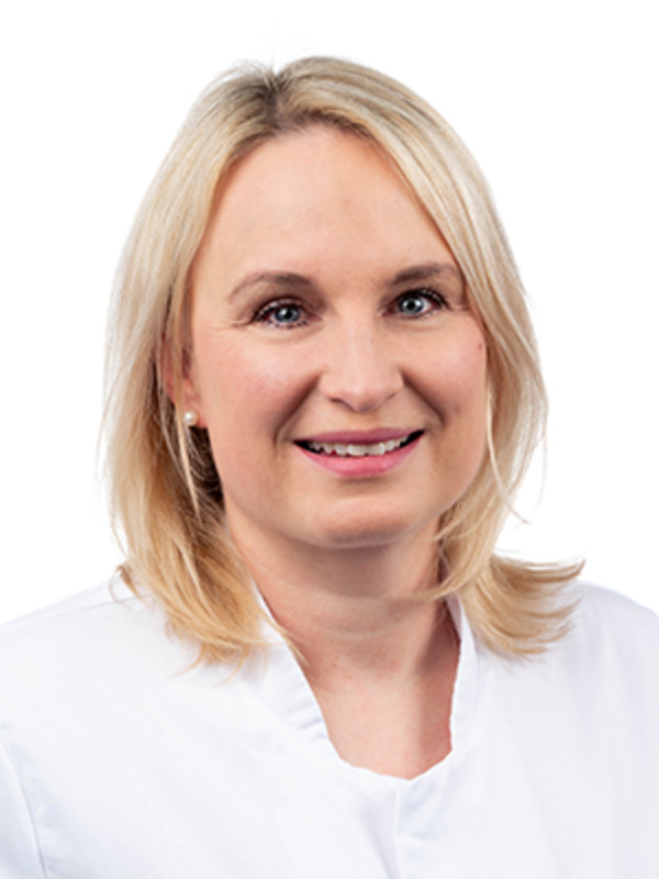 UKM | Fachzahnärztin für Parodontologie. Sie trägt einen weißen Kittel und lächelt.