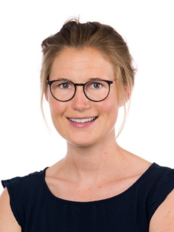 UKM Pädiatrische Hämatologie und Onkologie | Jasmin Finger | Sie trägt eine Brille und ein schwarzes Top und lächelt in die Kamera.