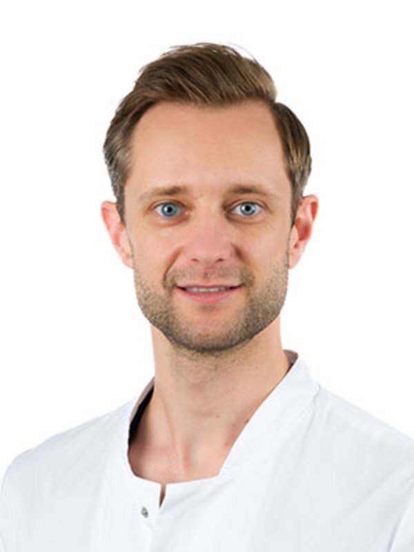 UKM Klinik für Radiologie | Marc Künnemann | Er trägt einen weißen Kittel und schaut in die Kamera.
