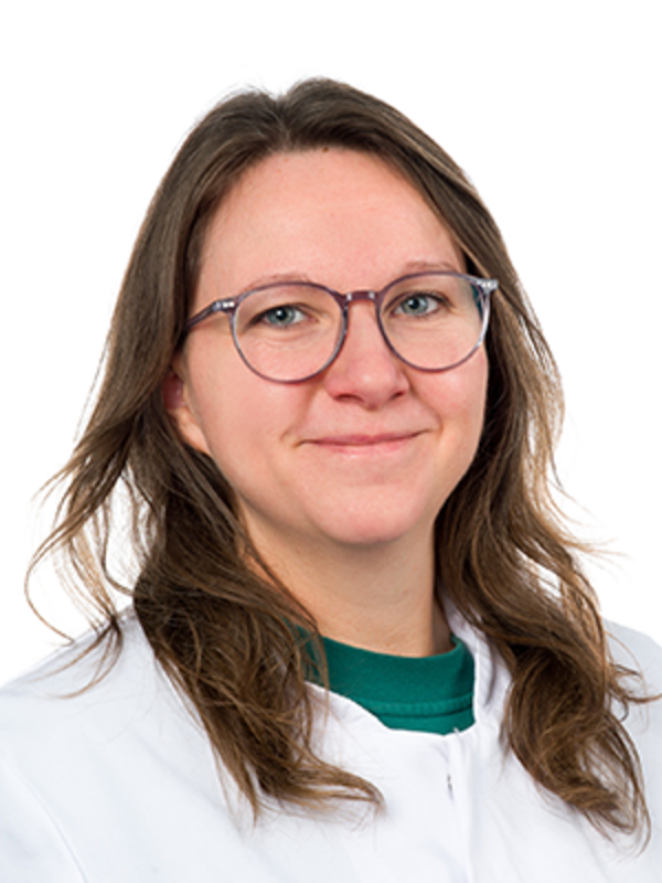 UKM | Labormitarbeiterin der Klinik für Parodontologie. Die Technische Assistentin trägt einen weißen Kittel, eine Brille und lächelt.