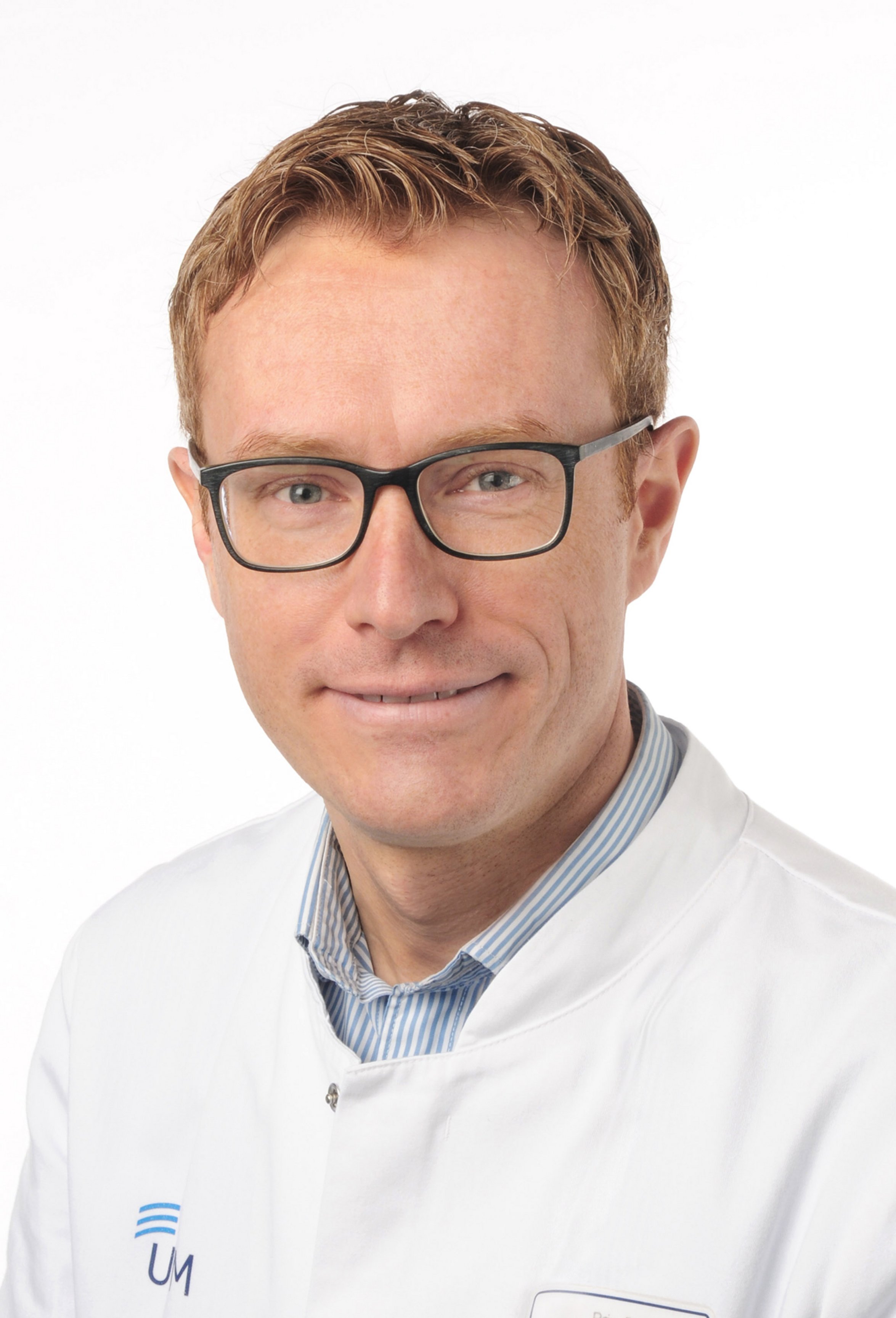UKM | Arzt der Klinik für Neurologie. Er trägt einen weißen Kittel, eine Brille und lächelt.