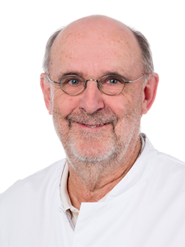 UKM | Portraitaufnahme eines Arztes aus dem Alterstraumazentrum. Er trägt eine Brille, einen weißen Kittel und lächelt.