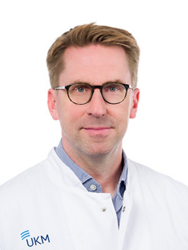 UKM EMAH | Stefan Orwat | Mann mit Brille und Kittel schaut freundlich in die Kamera.