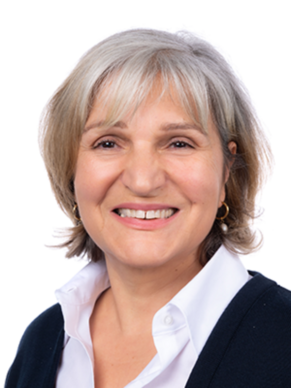 UKM | Portrait von Mitarbeiterin der Klinik für Parodontologie. Sie trägt eine schwarze Jacke und lächelt.