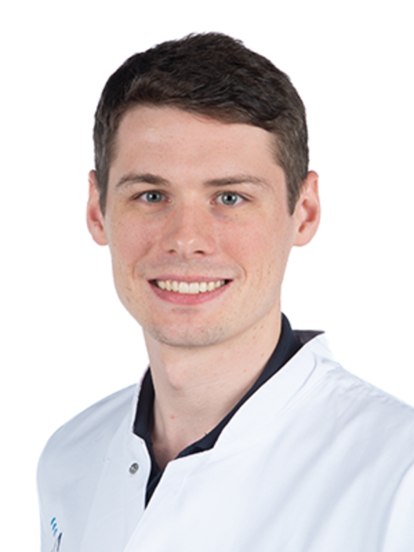 UKM | Arzt aus der Unfallchirurgie | Er trägt einen weißen Kittel und lächelt.