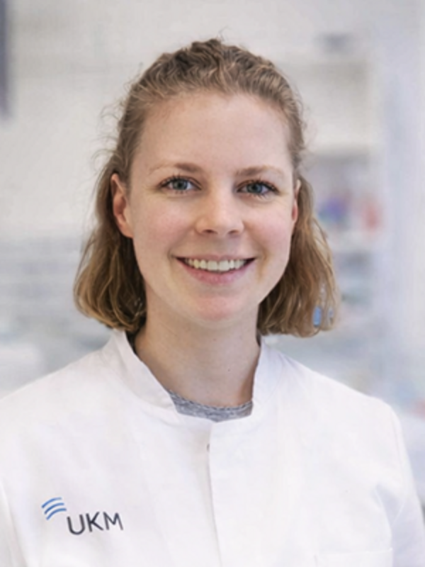 UKM | Labormitarbeiterin im Forschungsteam der Gefäßchchirurgie. Sie trägt einen weißen Kittel und lacht.