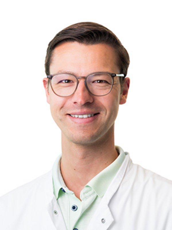UKM Plastische Chirurgie | Jan Feldmann | Mann mit Brille lächelt in die Kamera.
