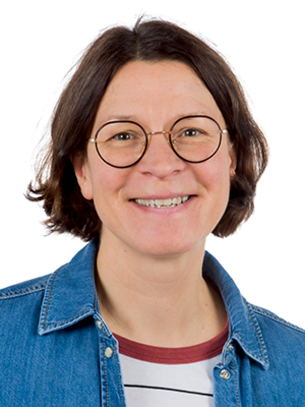 UKM Unfallchirurgie | Pflegeexpertin Claudia Bamming. Sie trägt Jeansjacke und Brille und lacht