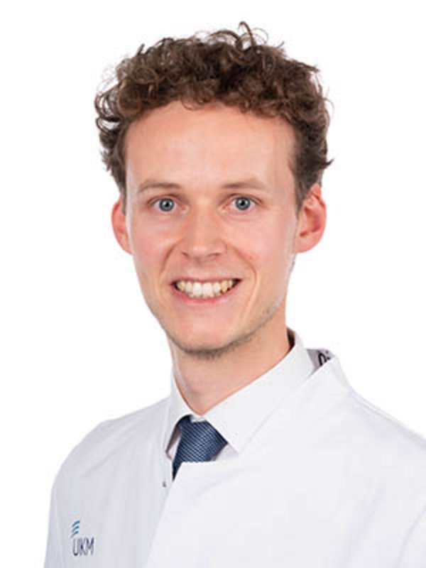 UKM Klinik für Strahlentherapie | Julius Vahle | Er hat braune Haare, trägt einen Kasack und lächelt in die Kamera.
