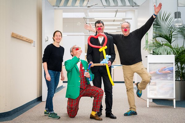 UKM Spenden und Helfen | Gruppenbild mit einer Frau und drei Männern. Die Männer haben Clowns-Nasen auf und posen für die Kamera. Alle lachen.