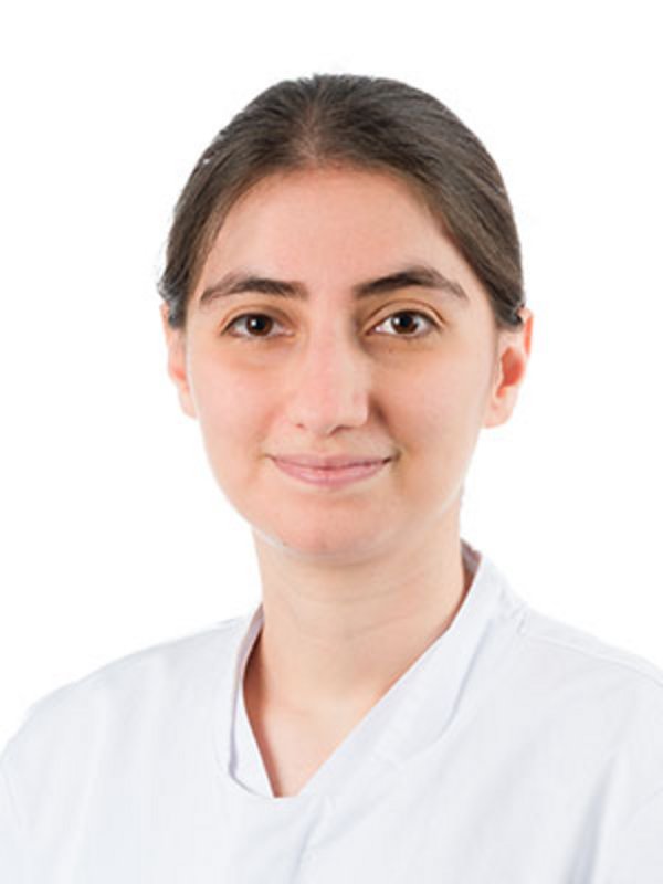 UKM Klinik für Nuklearmedizin | Esra Degerli | Sie hat braune Haare, trägt einen weißen Kittel und lächelt in die Kamera.