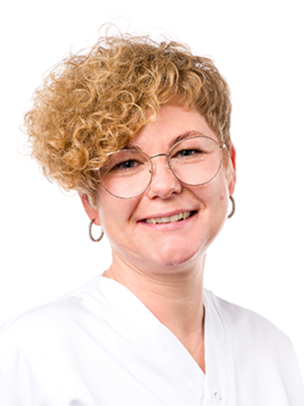 UKM | Zahnmedizinische Prophylaxeassistentin aus der Klinik für Parodontologie. Sie trägt einen weißen Kasack und lächelt.