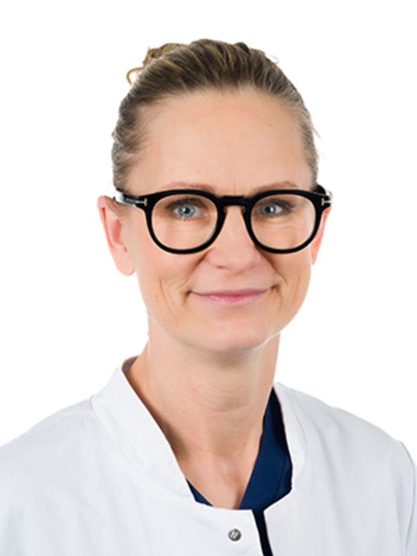 UKM | Portrait einer Ärztin der Unfallchirurgie. Sie trägt einen weißen Kittel und lächelt.