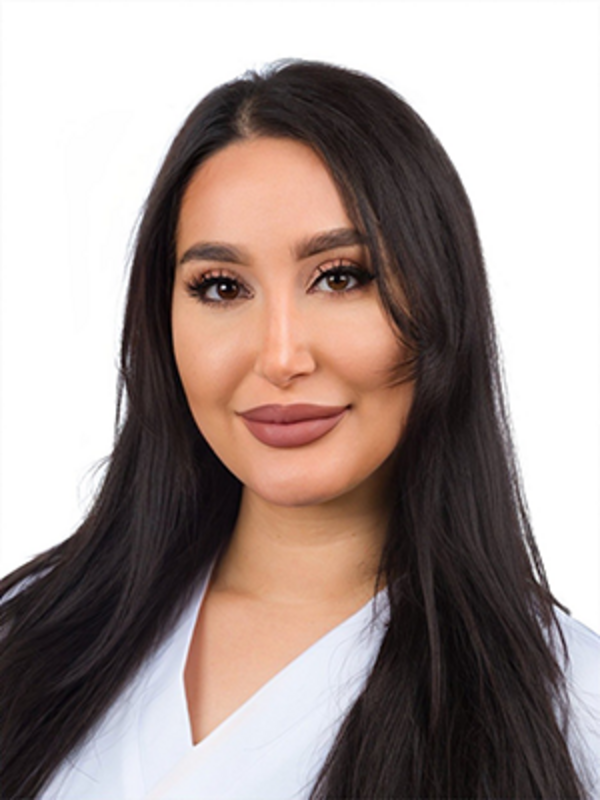 UKM | Portraitfoto einer Medizinischen Fachangestellten aus der Angiologie. Sie trägt einen weißen Kasack und lächelt.