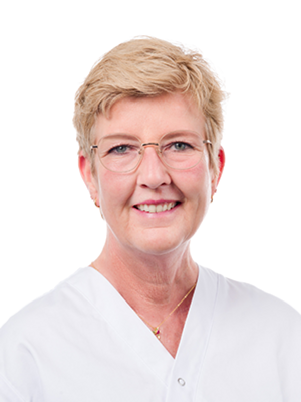 UKM | Portraitaufnahme einer Zahnmedizinischen Prophylaxeassistentin der Klinik für Parodontologie. Sie trägt eine Brille, einen weißen Kasack und lächelt.