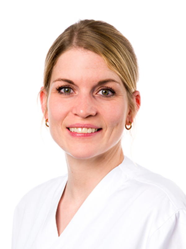 UKM | Portrait einer Dentalhygienikerin der Klinik für Parodontologie. Sie trägt einen weißen Kasack und lächelt.