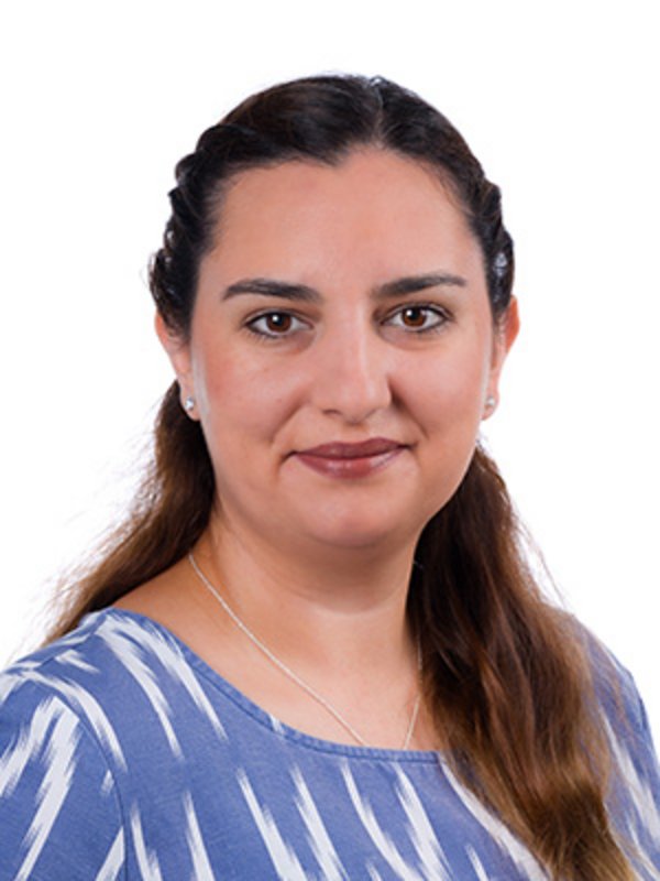 UKM Medizinische Klinik D | Jasmina Ceylan | Sie trägt ein blau-weißes Oberteil, hat dunkle Haare und lächelt in die Kamera.