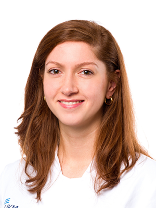 UKM | Fachzahnärztin der Klinik für Parodontologie. Sie trägt einen weißen Kittel und lächelt.