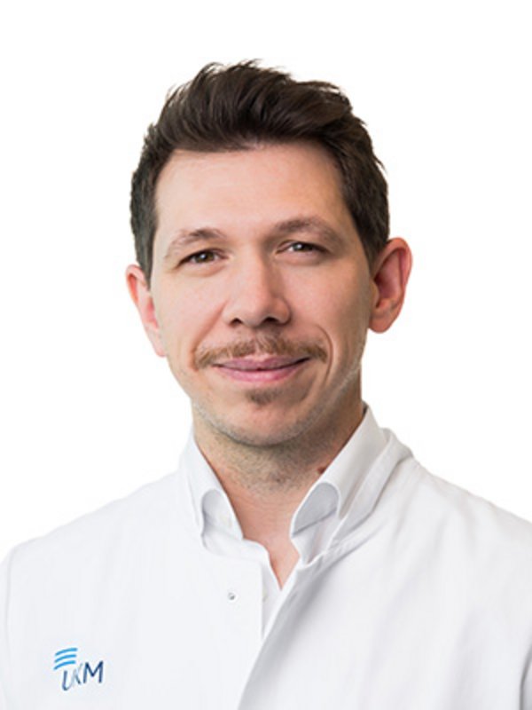 UKM Plastische Chirurgie | David Kampshoff | Mann mit braunen Haaren schaut in die Kamera.