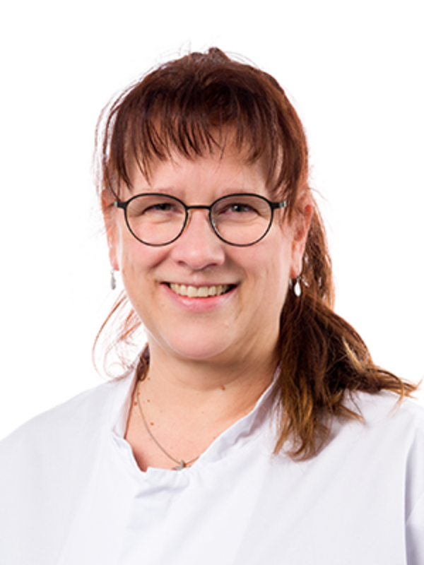 UKM | Medizinsch Technologin für Laboratoriumsanalytik in der Klinik für Parodontologie. Sie trägt einen weißen Kittel, eine Brille und lächelt.