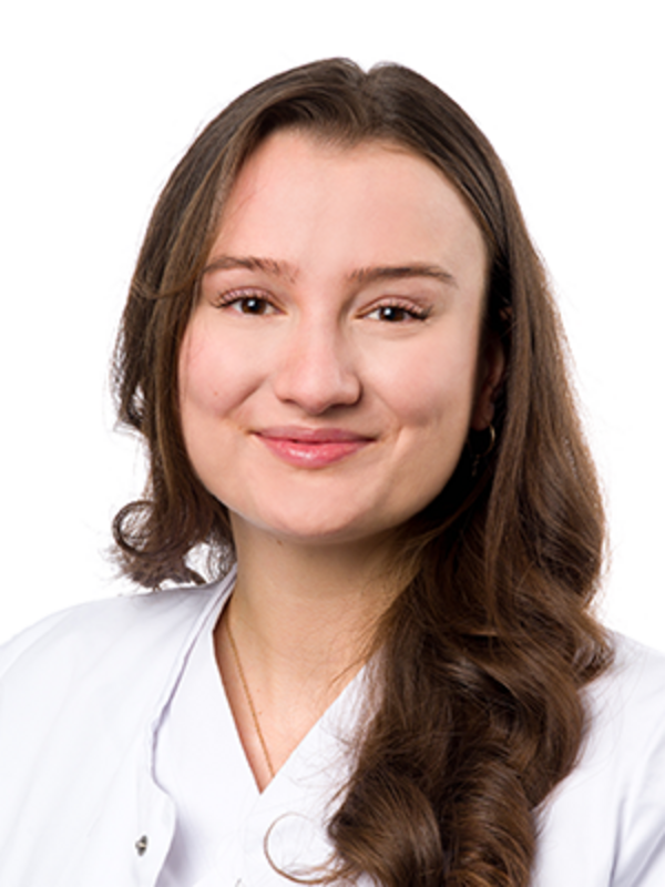 UKM | Portrait einer Zahnärztin der Klinik für Parodontologie. Sie trägt einen weißen Kittel und lächelt.